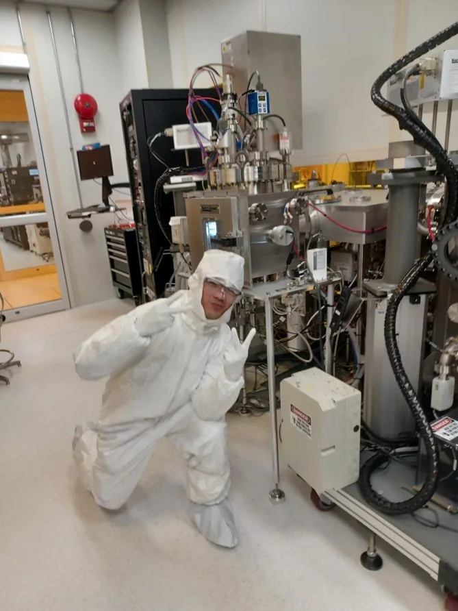 Timothy Molino in cleanroom clothing beside laboratory equipment